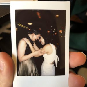A polaroid of Kaila and Maral at her wedding holding each other and touching foreheads