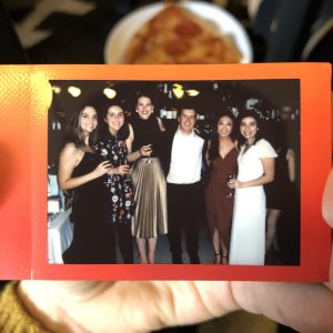 A polaroid with a group of people at a wedding holding drinks