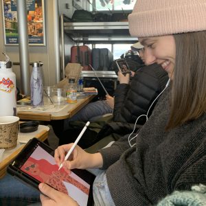 Kaila Elders draws on her ipad on a ferry