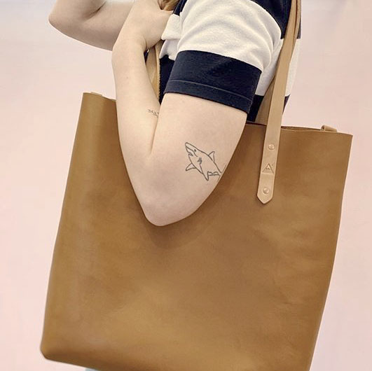 A close up of a woman holding a leather bag