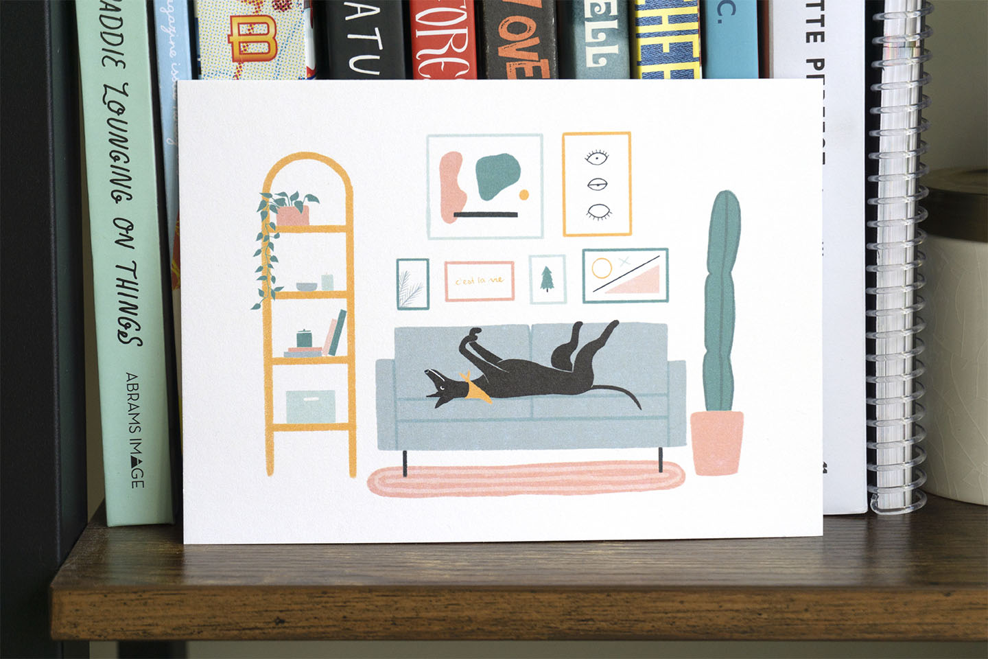 An art print of a greyhound napping in a living room