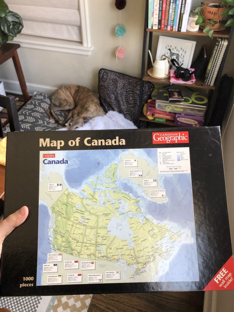 A hand holds the box for a map of Canada puzzle