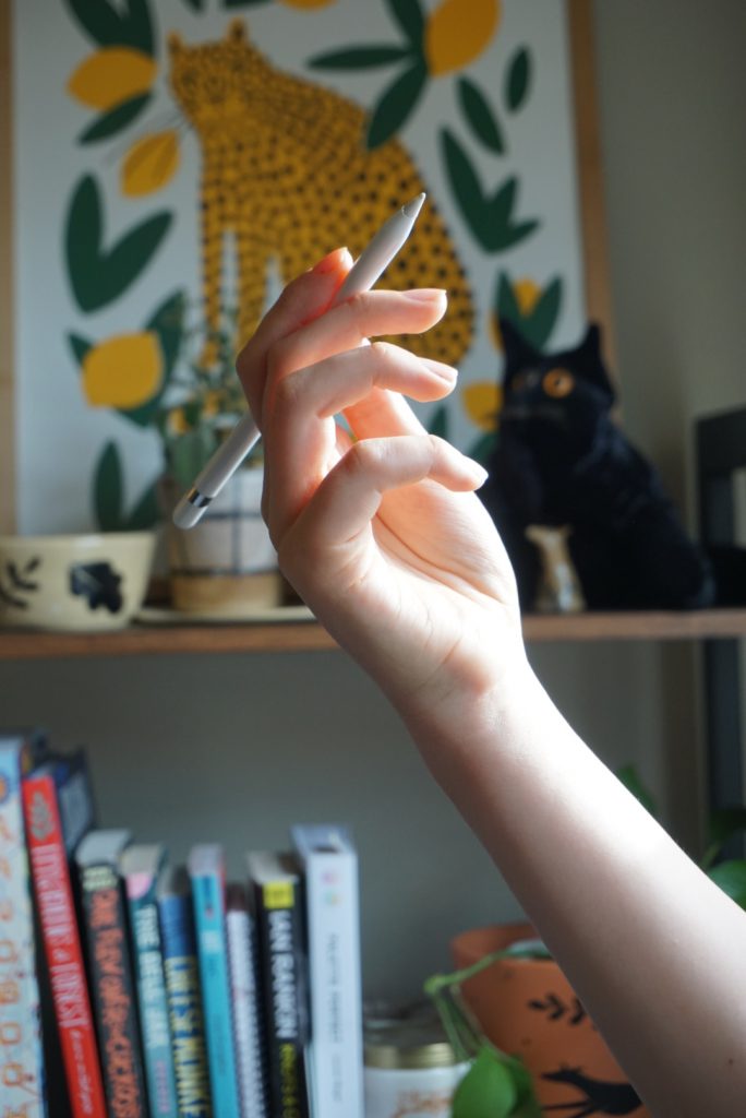 A hand holding an Apple Pencil