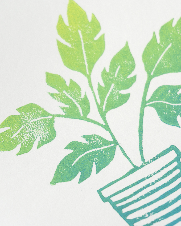 A linocut print of a potted plant, in a gradient colour of light green to blue
