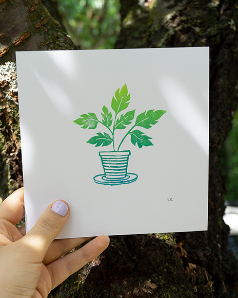 A linocut print of a potted plant, in a gradient colour of light green to blue