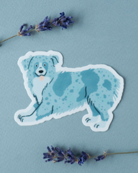 A sticker of a blue Australian Shepherd between two small flowers