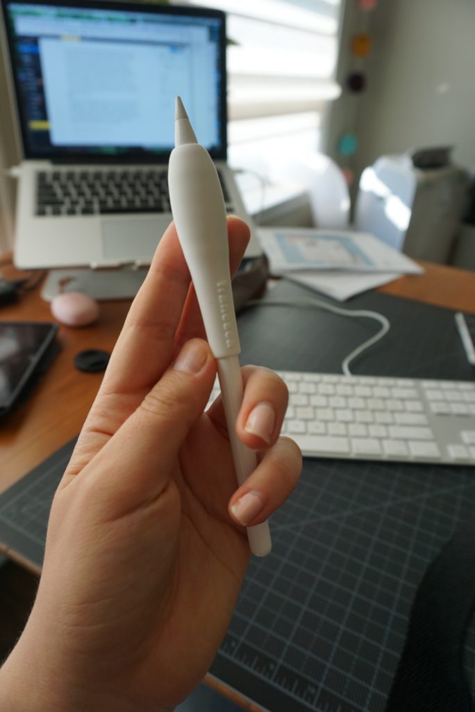 A hand holding an apple pencil with a large grip on it