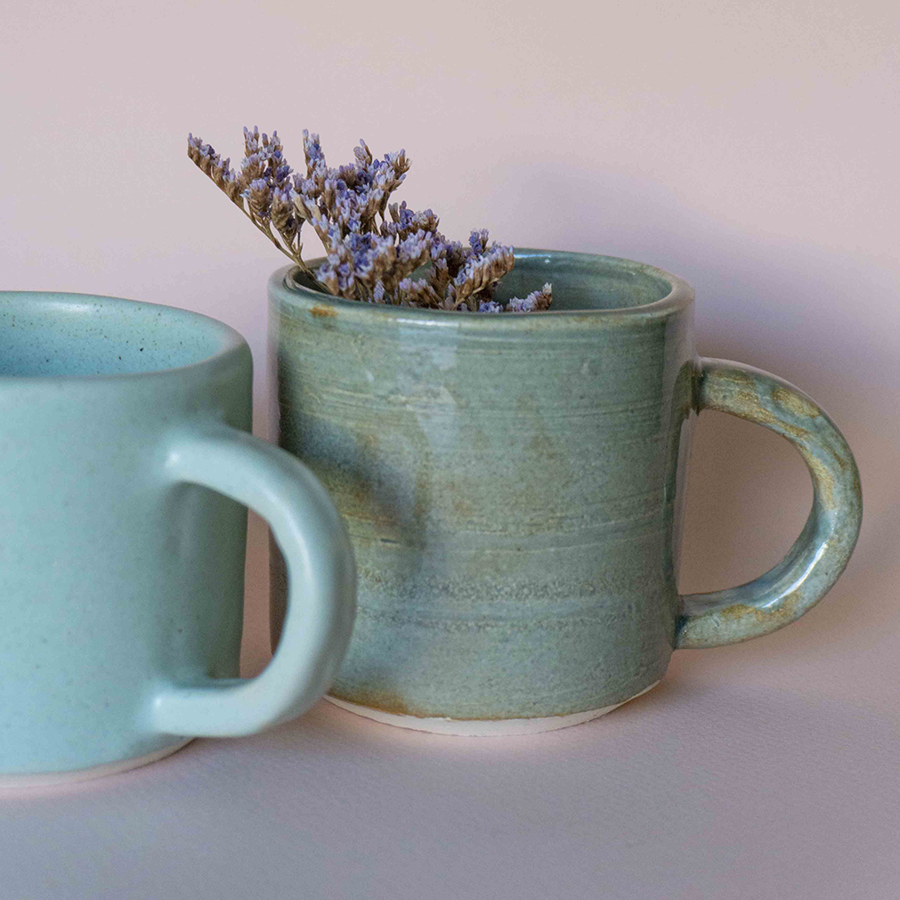 Two ceramic mugs with lavender sprigs inside one of them